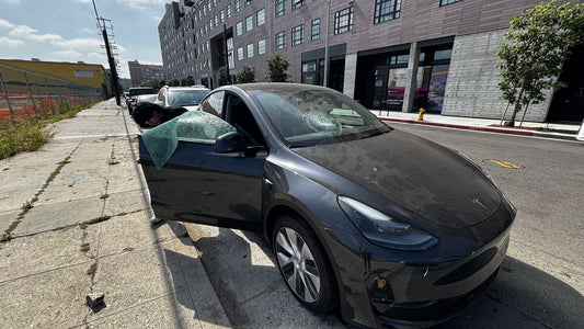Technician replacing a cracked windshield on-site in Los Angeles with Auto Glass Security truck in background